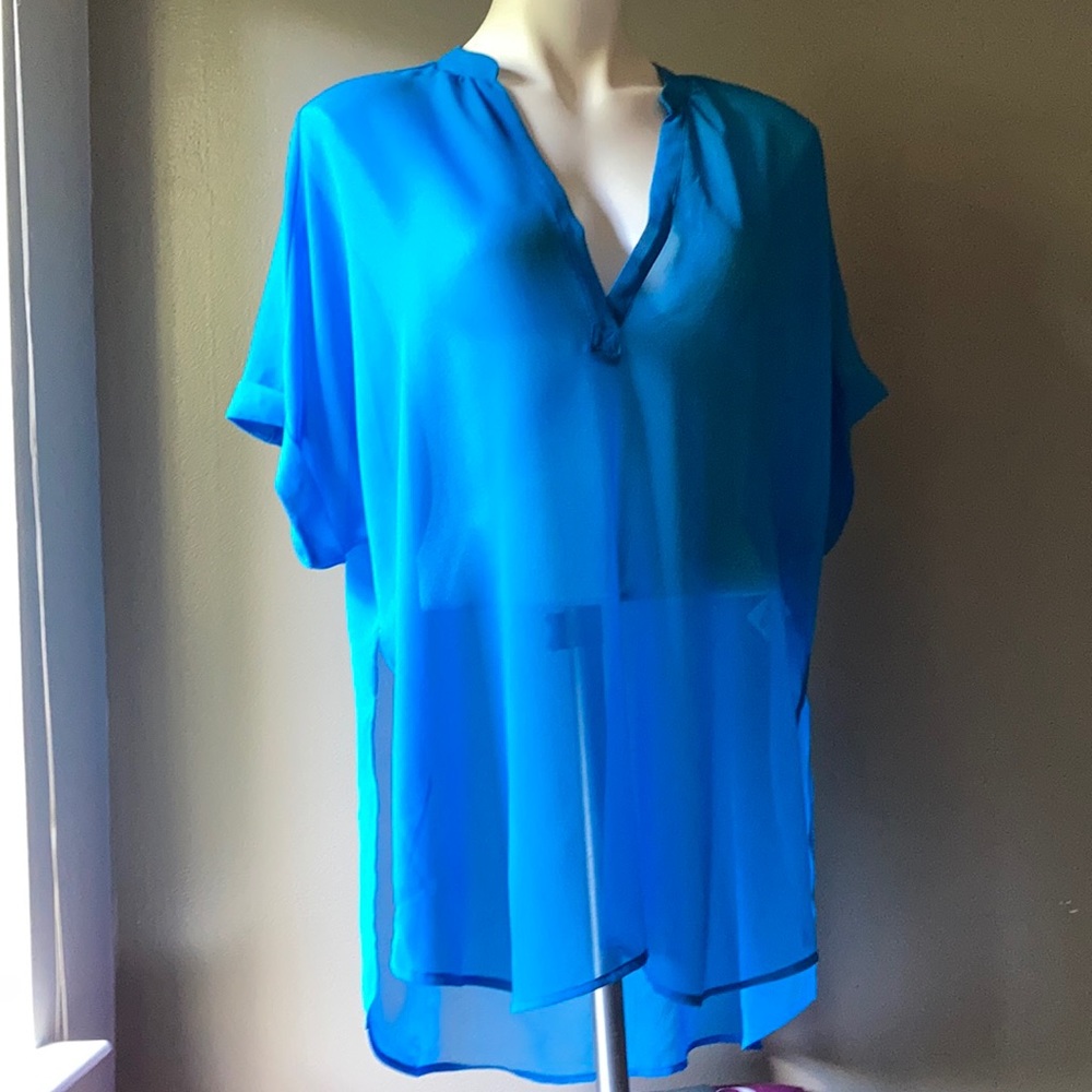 This is a bright blue V-neck top with a relaxed, flowy fit.